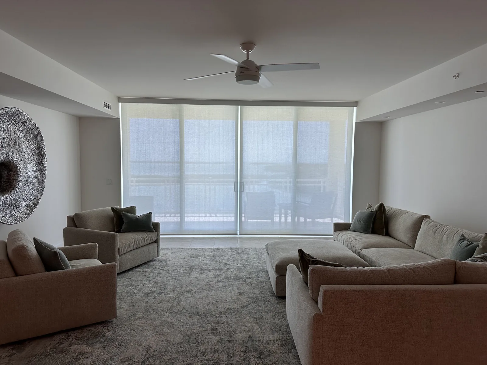 Light-filtering roller shades across an oceanfront living room