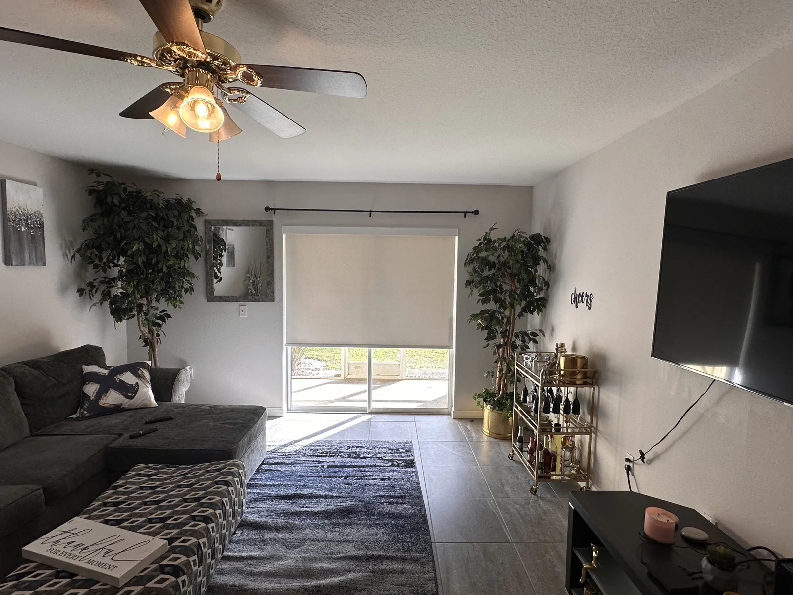 Neutral roller shade installed over a living room sliding door