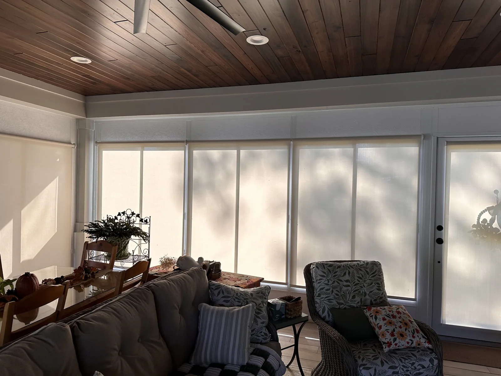 Coordinated light-filtering shades across sunroom windows