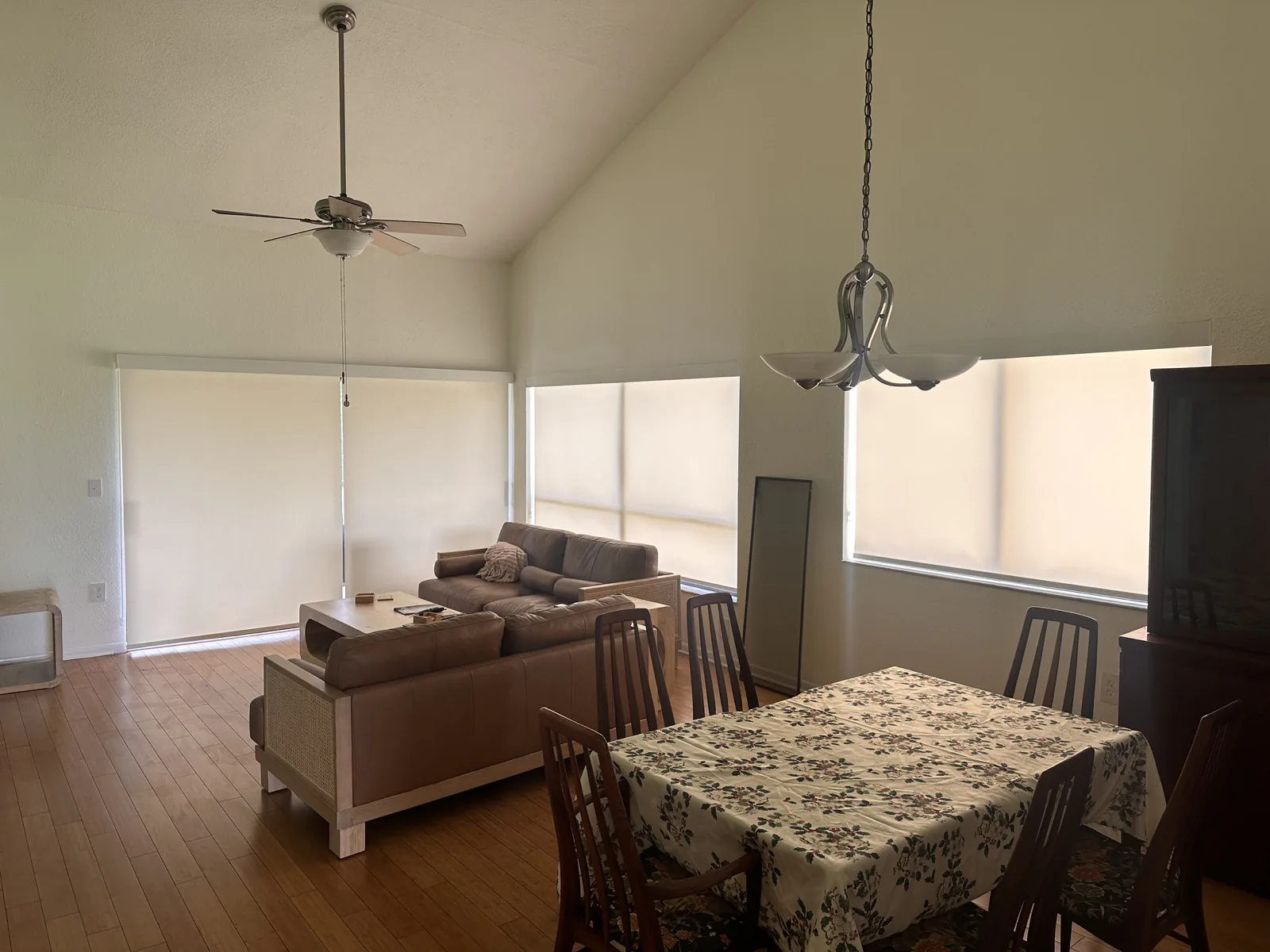 Motorized shades covering tall living and dining room windows