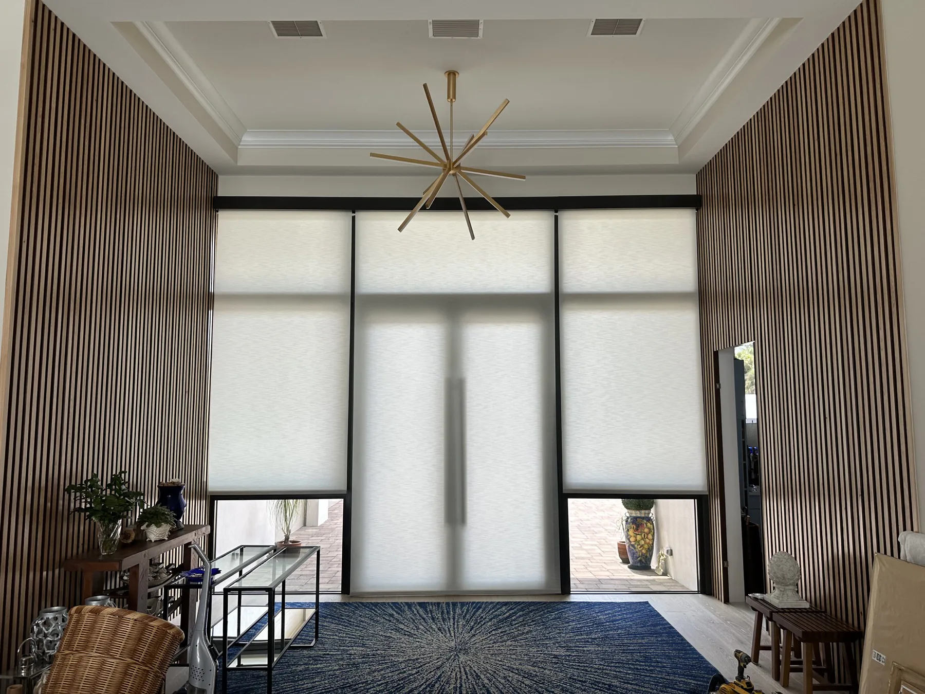 Custom motorized roller shades installed across tall windows in a Treasure Coast home